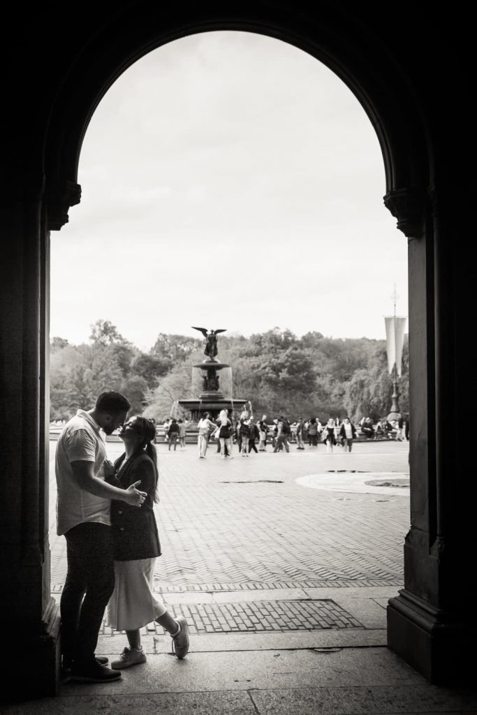 Black and white photo of couple standing in archway leading to Bethesda Fountain