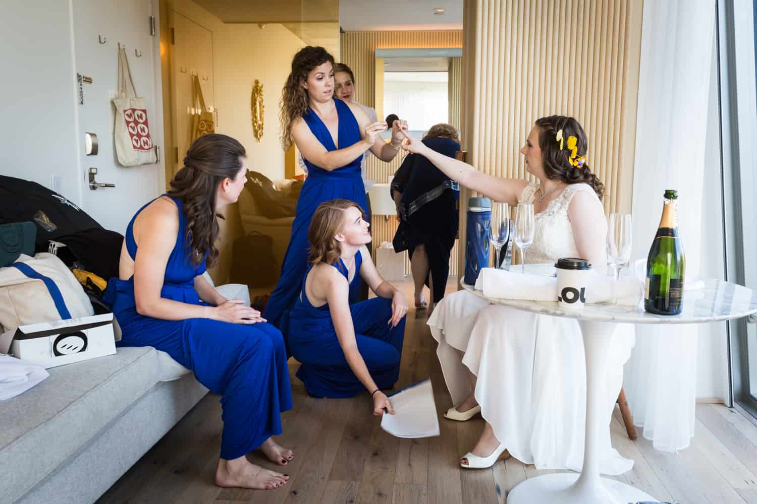 Bride in hotel room being attended by bridesmaids