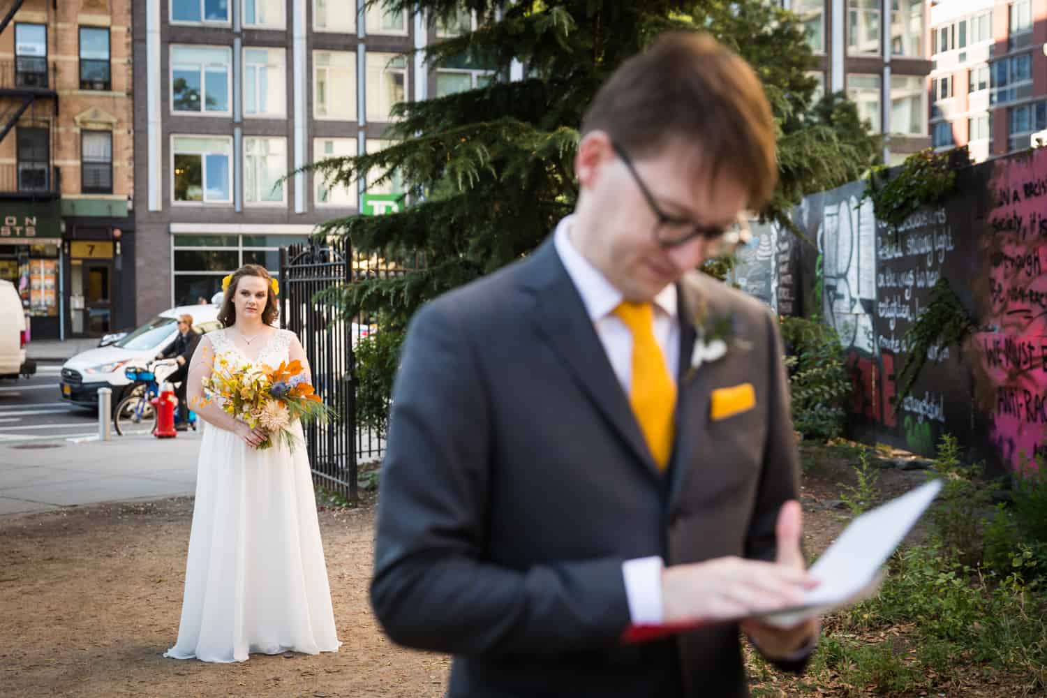 Groom reading letter with bride behind him