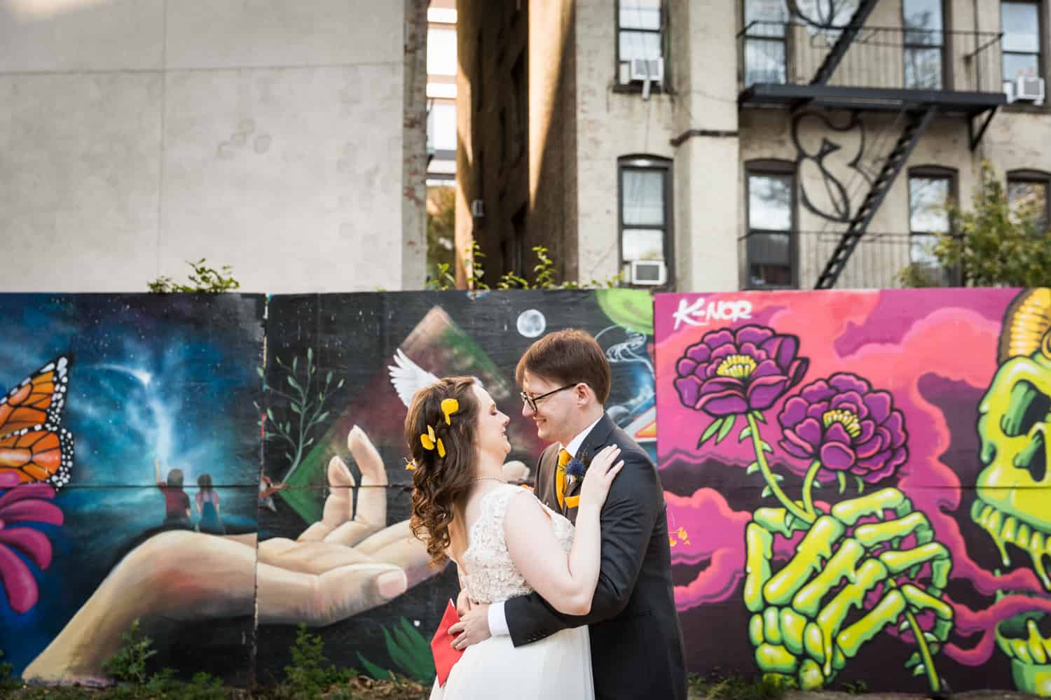 Bride and groom hugging in front of graffiti for an article on Covid-19 wedding planning