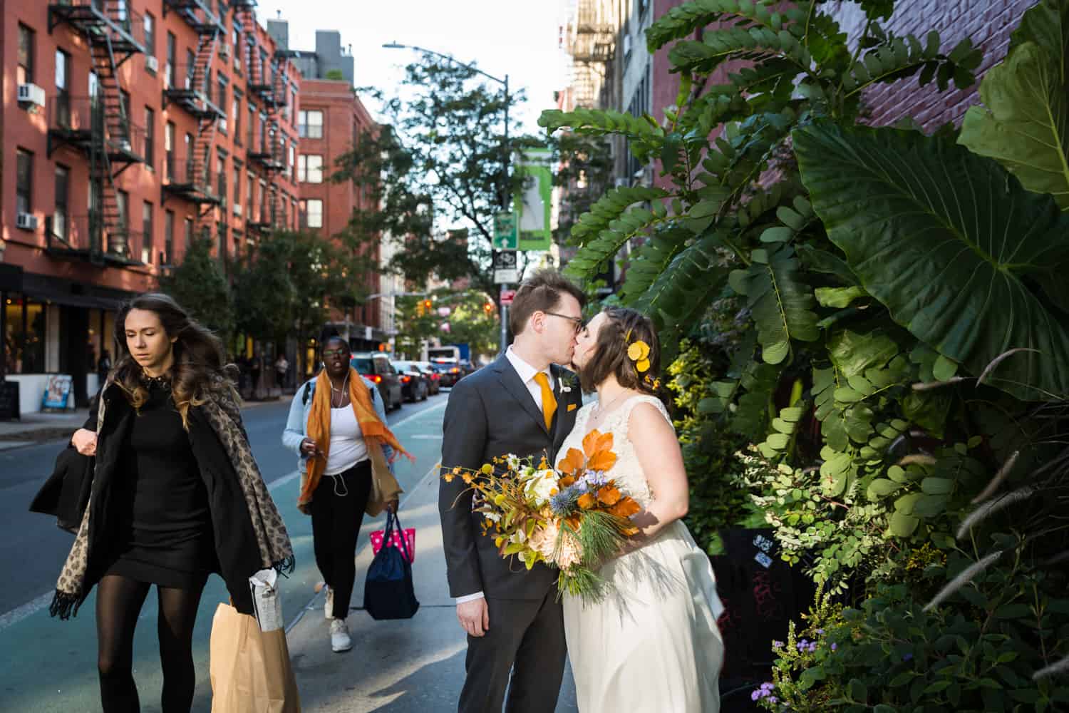 Bride and groom kissing on sidewalk for an article on Covid-19 wedding planning