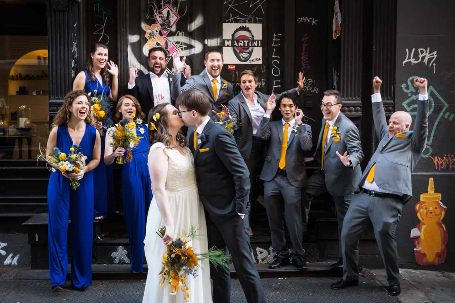 Bridal party cheering as bride and groom kiss for an article on Covid-19 wedding planning