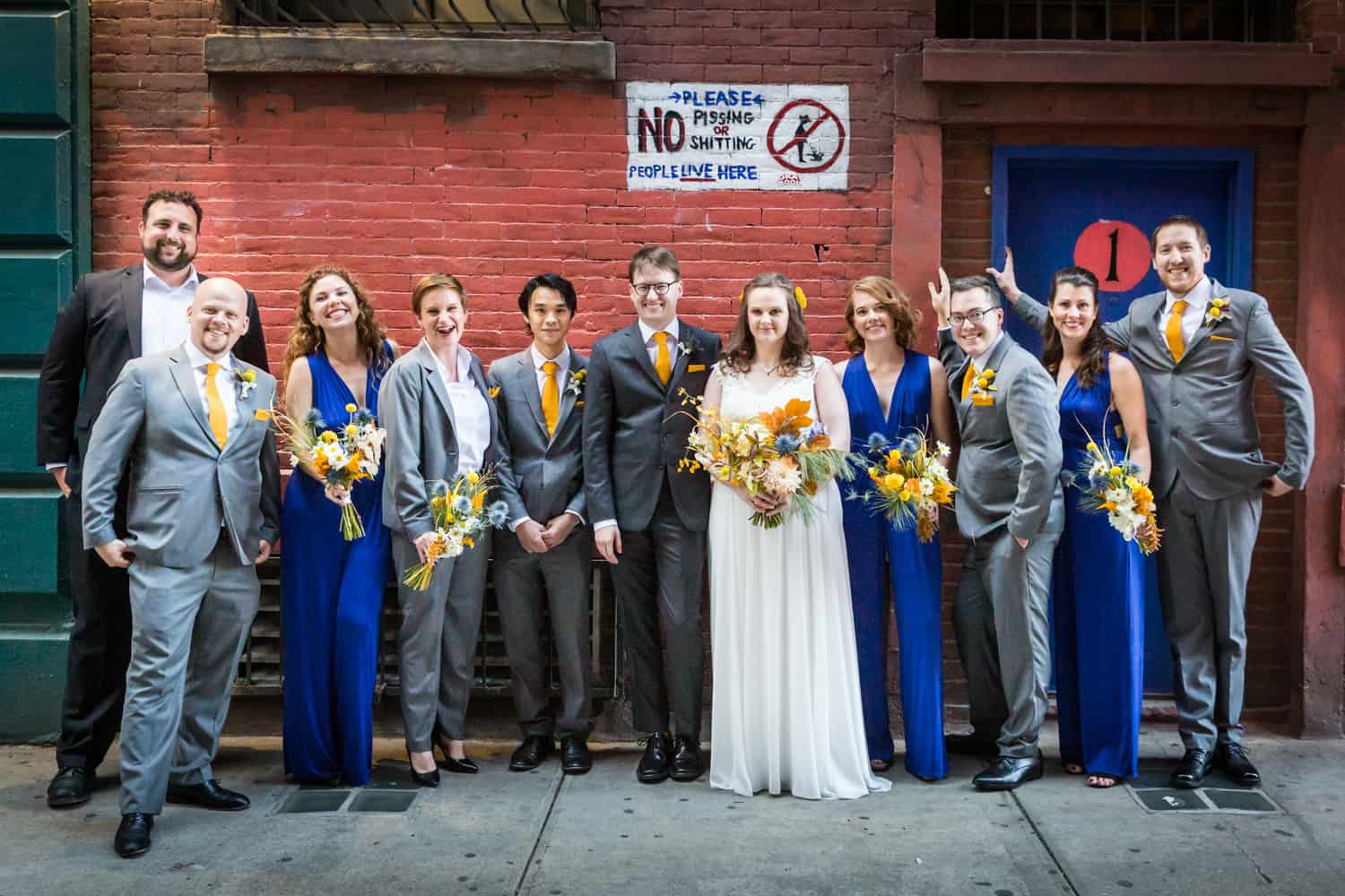 Bridal party standing in front of sign for an article on Covid-19 wedding planning
