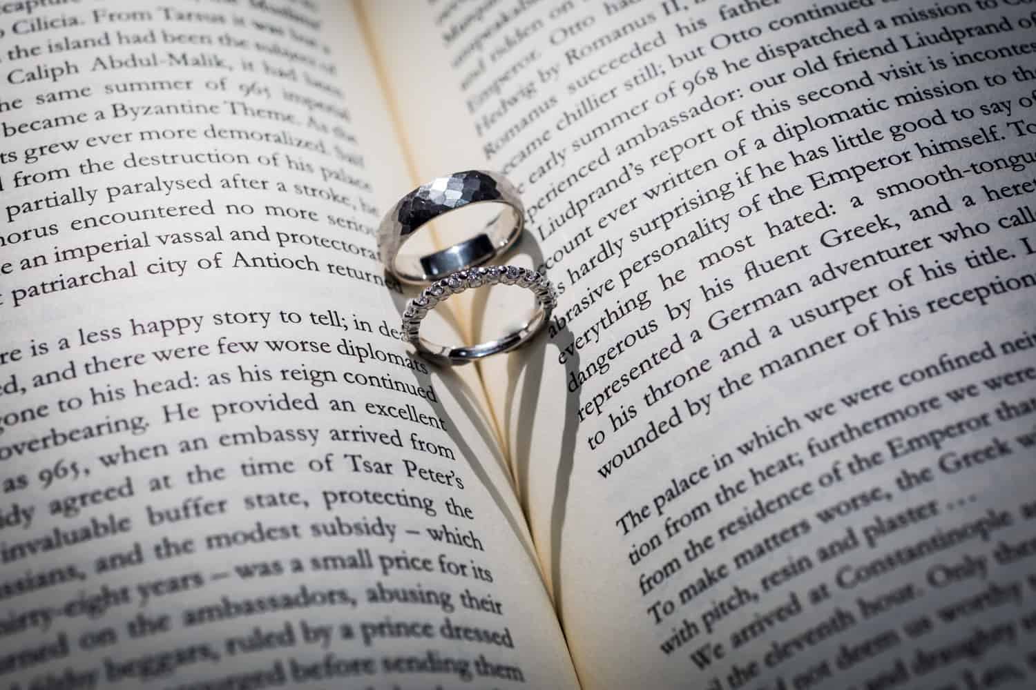 Wedding rings in center of book with heart-shaped shadow