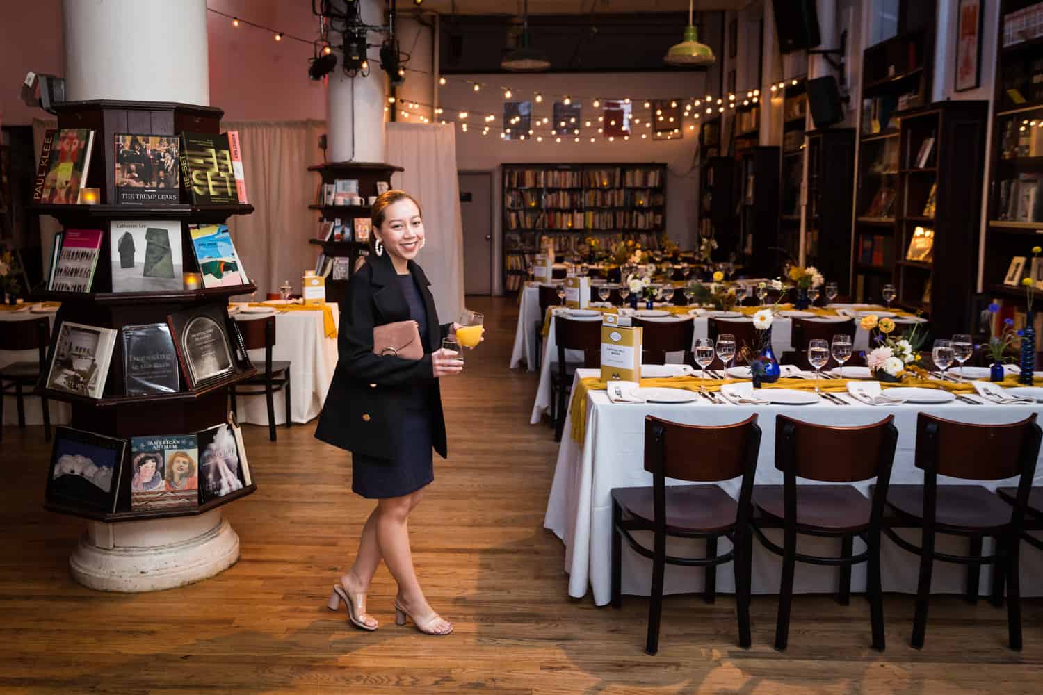 Female guest standing in front of tables at a Housing Works Bookstore Cafe wedding