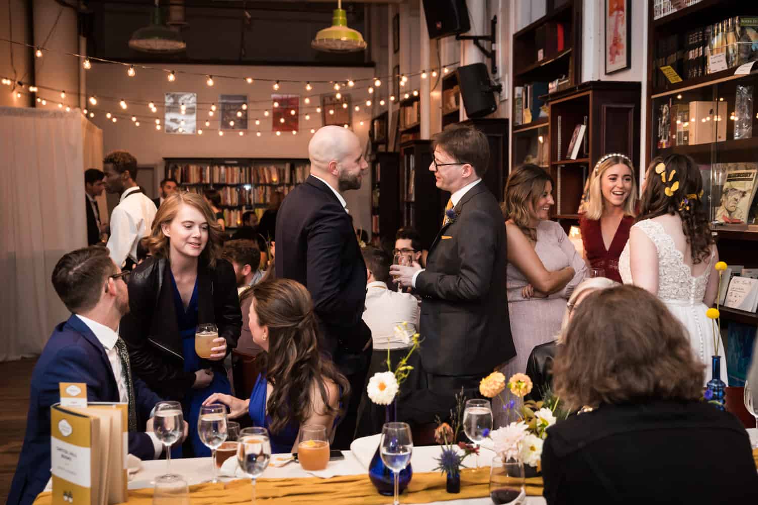 Guests chatting with bride and groom at a Housing Works Bookstore Cafe wedding