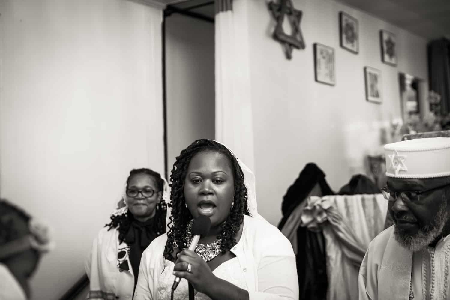 Black and white photo of woman singing during Jamaica christening