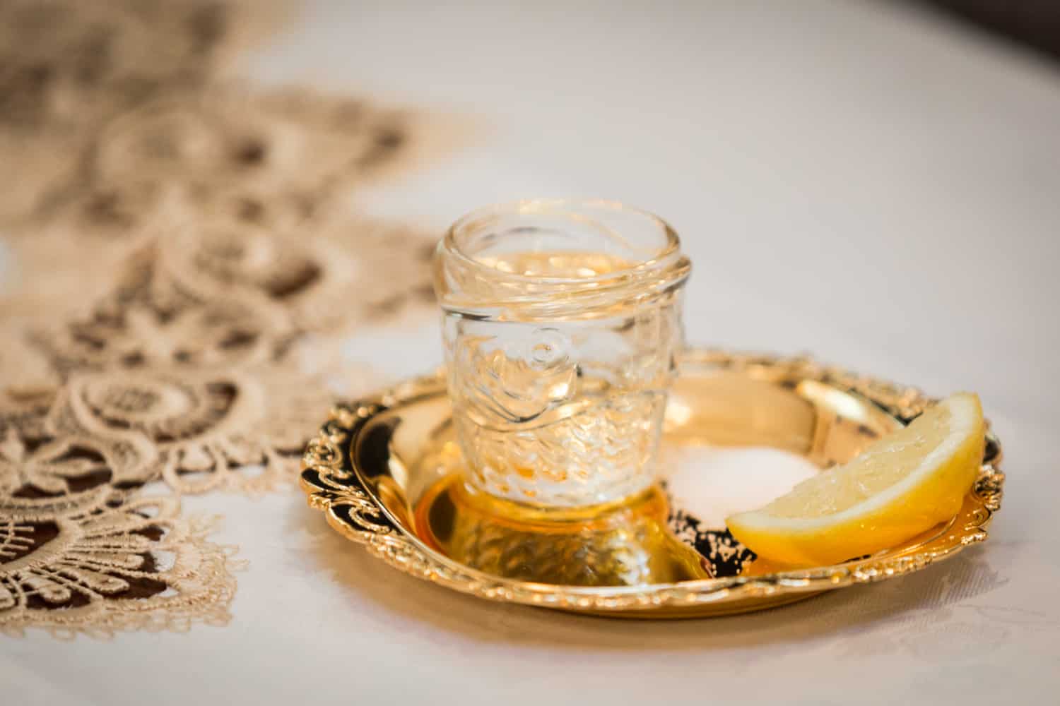 Gold plate with lemon slice and small jar of honey