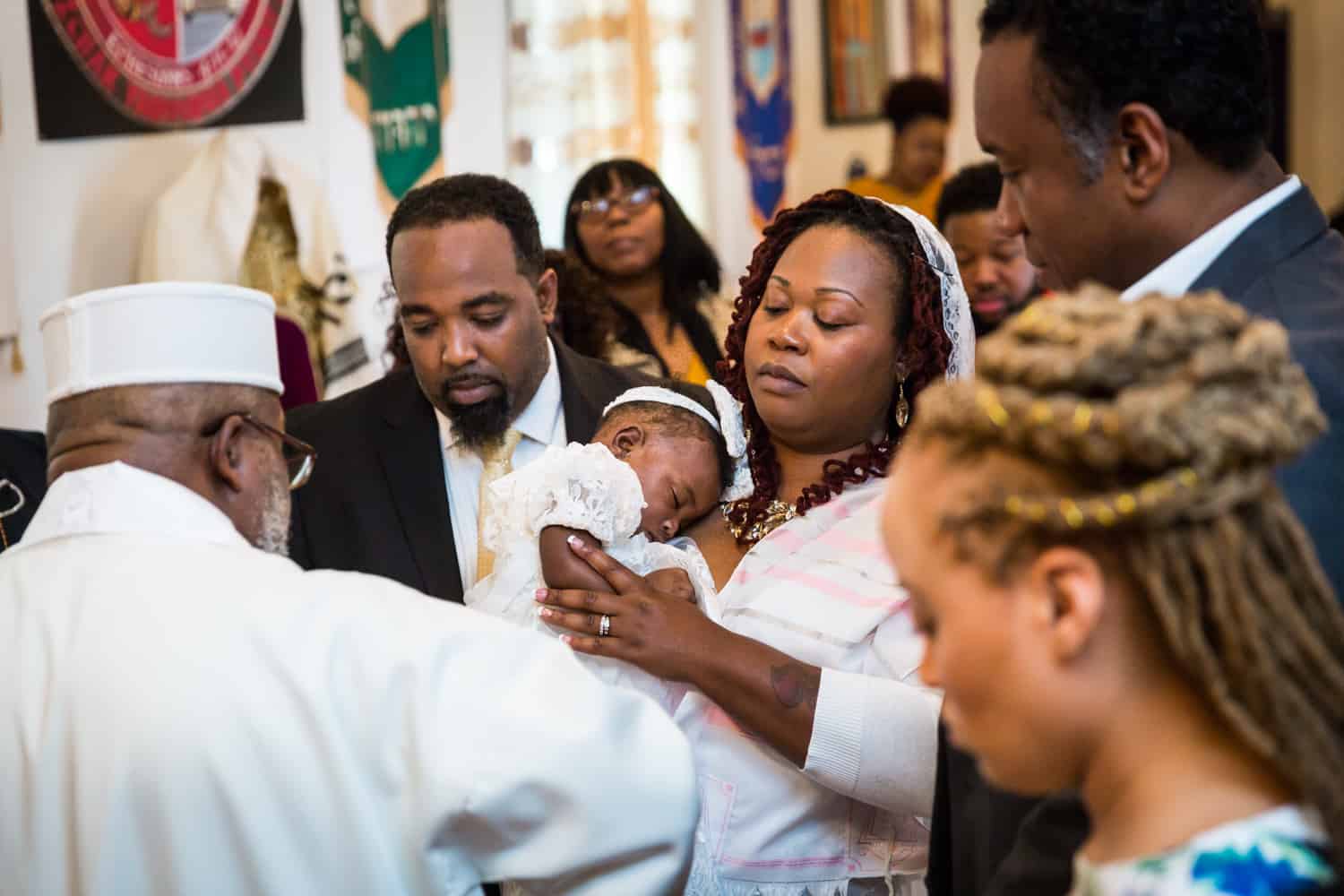 Parents holding baby during Jamaica christening blessing