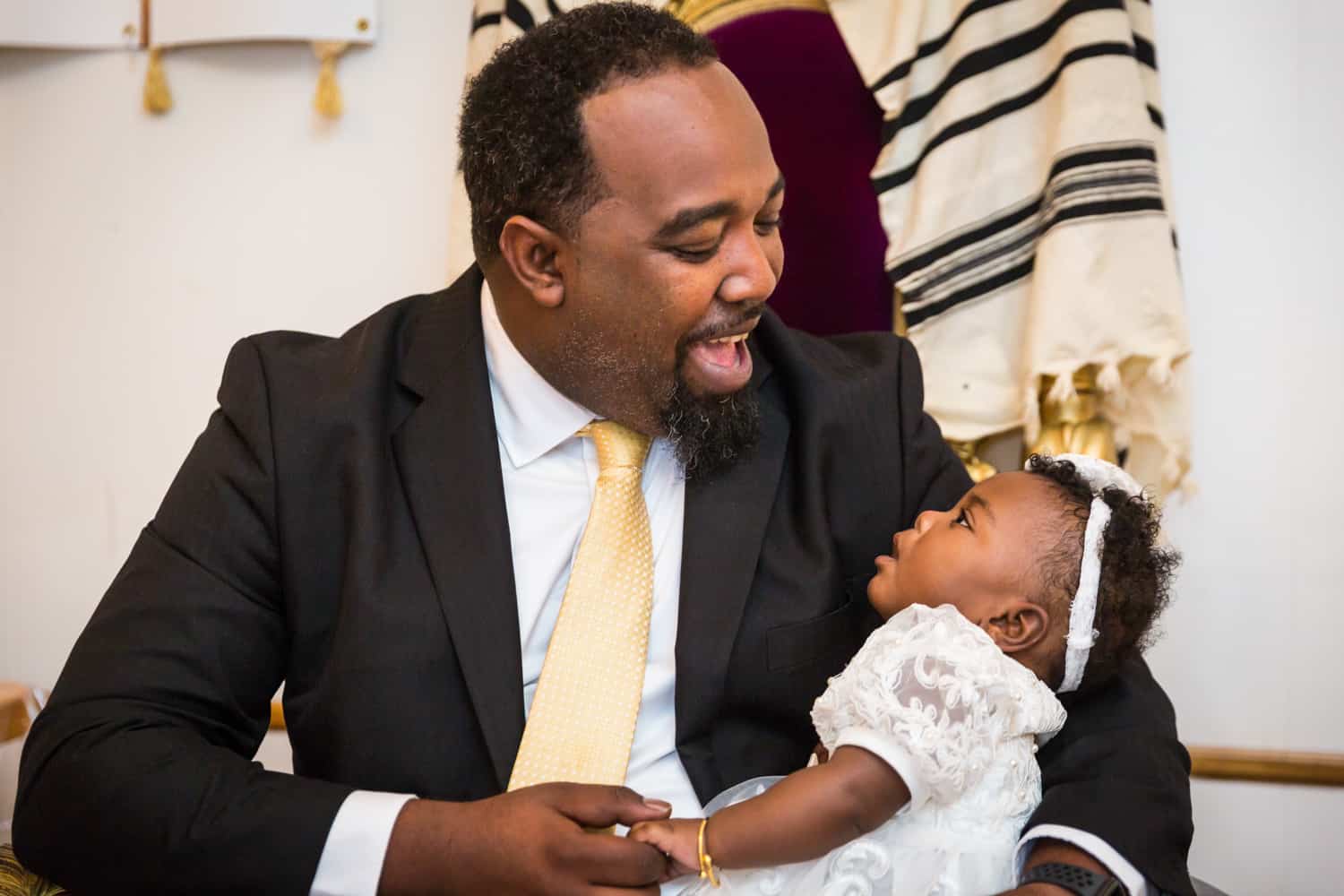 African American father laughing with little baby on his lap