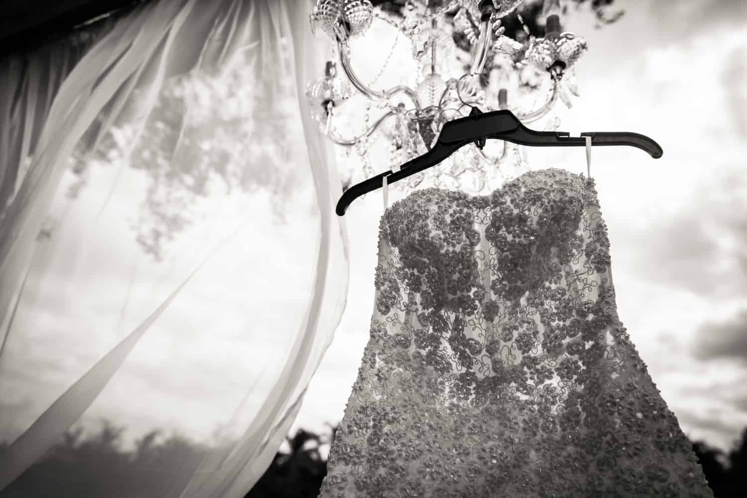 Black and white photo of sleeveless wedding dress on hanger