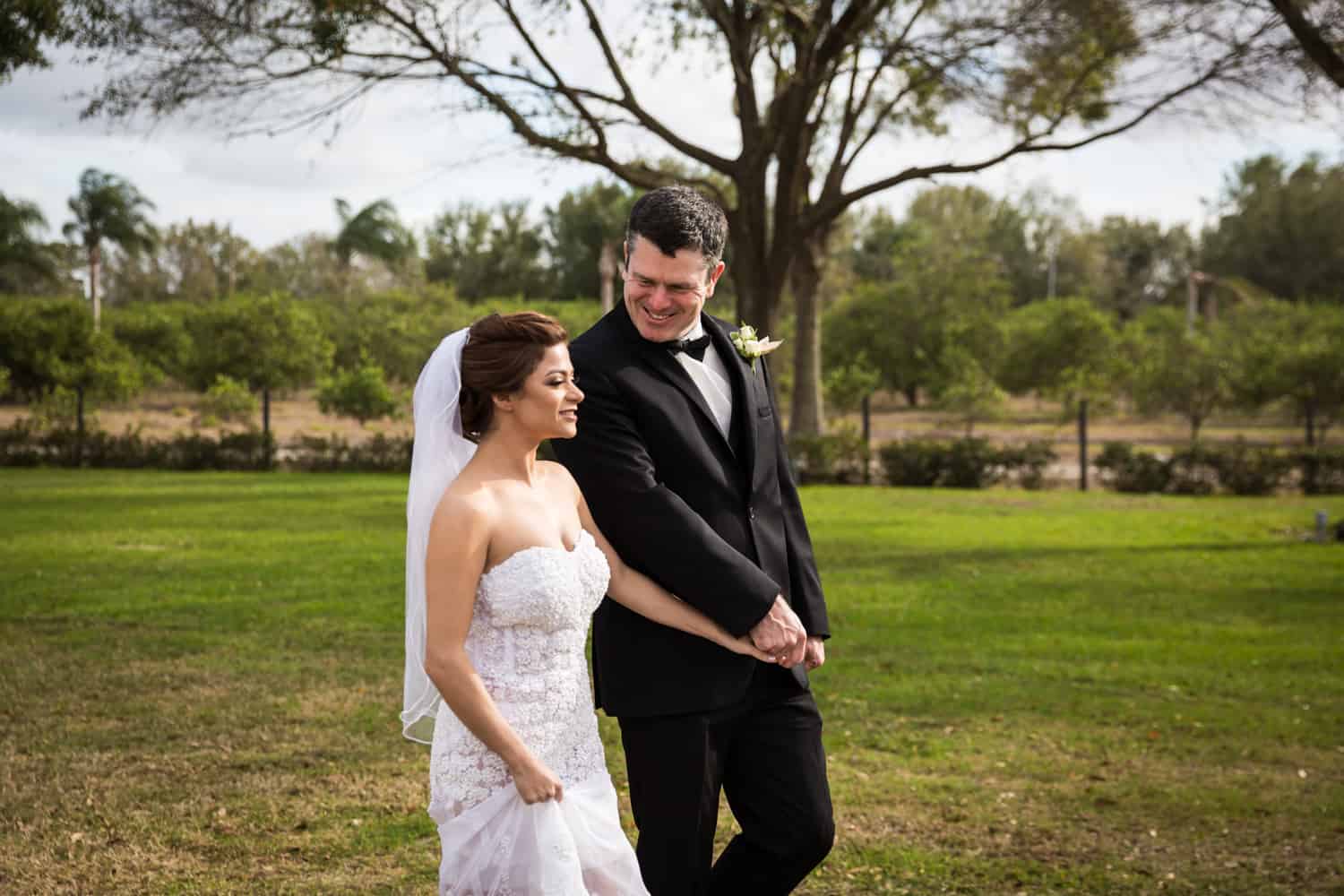 Bride and groom holding hands and walking for an article on wedding cost cutting tips