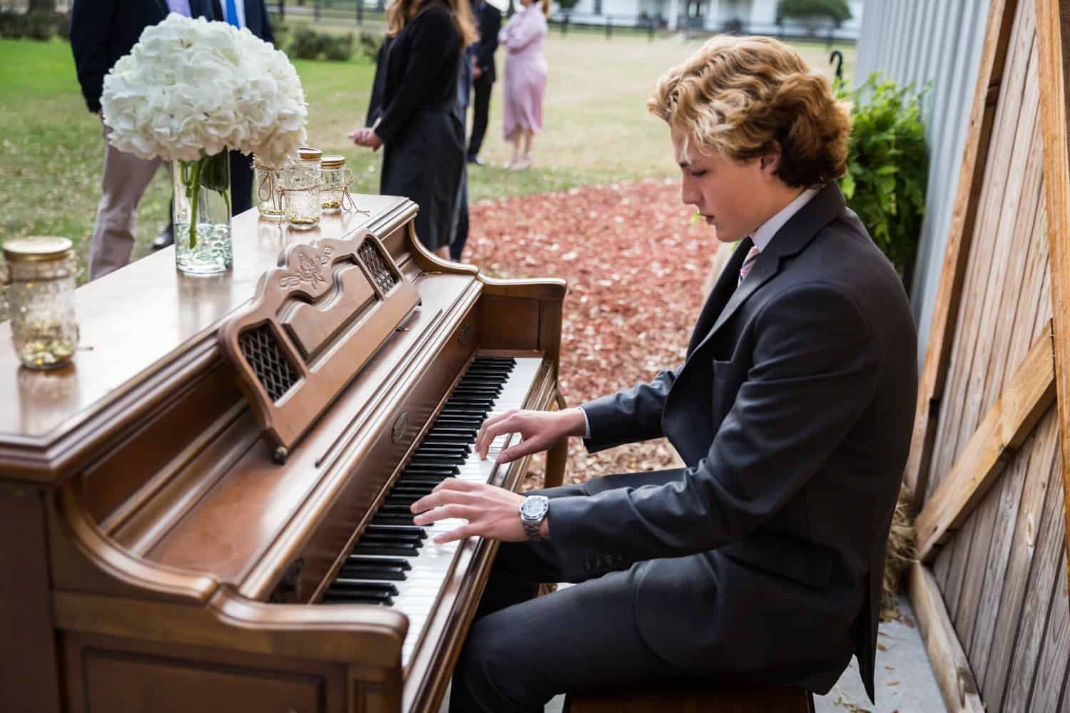 Young man playing piano for an article on wedding cost cutting tips