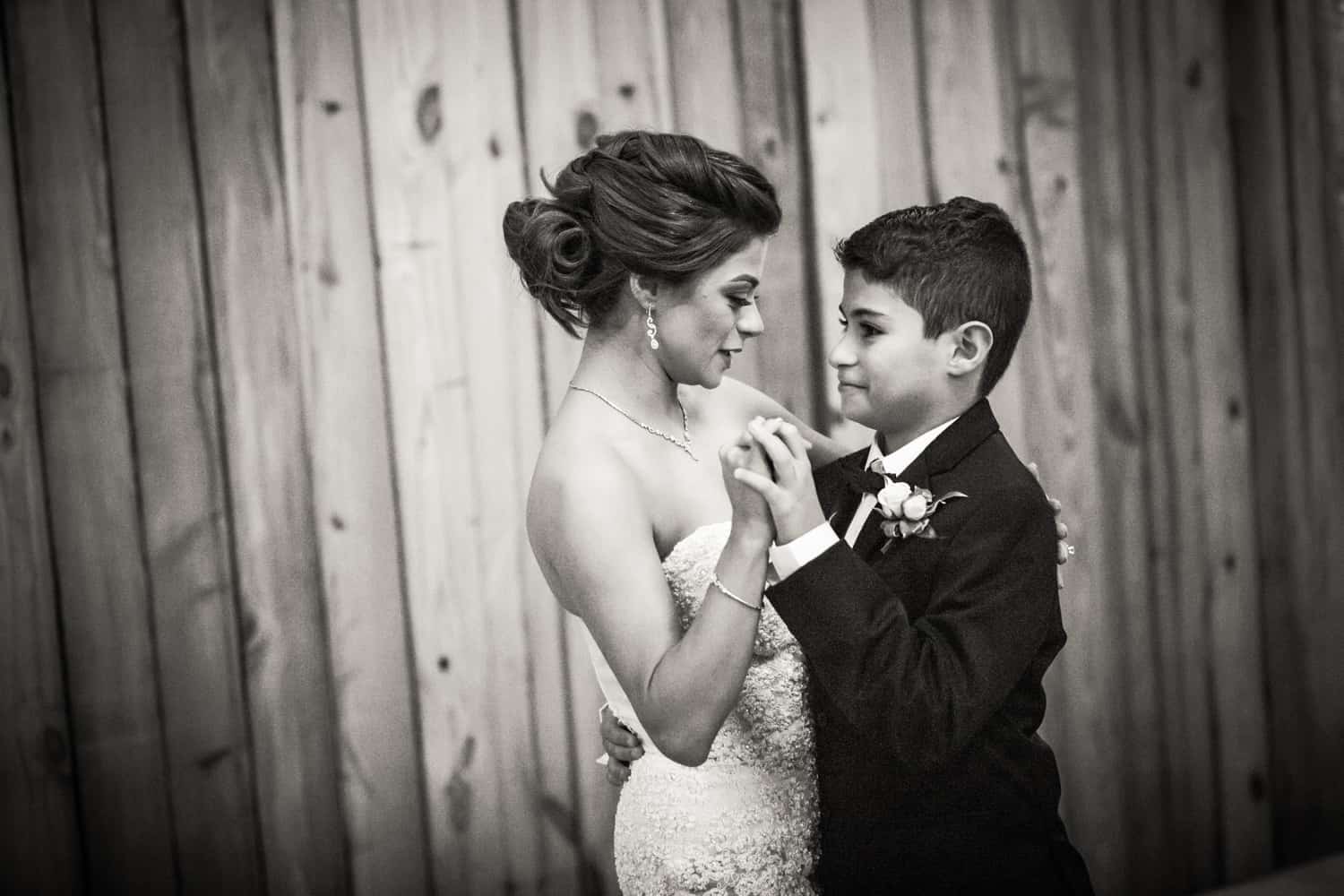Black and white photo of bride dancing with son