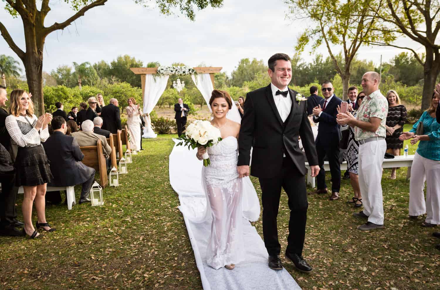 Bride and groom walking down aisle after ceremony for an article on wedding cost cutting tips