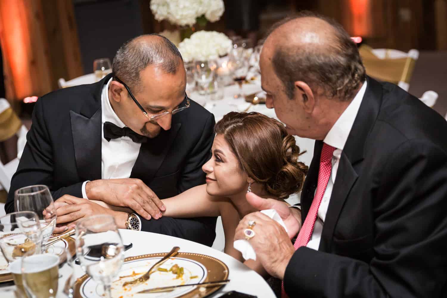 Bride talking with two men at table during Florida wedding reception