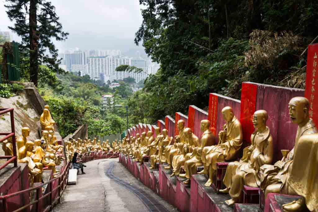 Line of golden buddha sculptures in the Ten Thousand Buddhas Monastery in Hong Kong