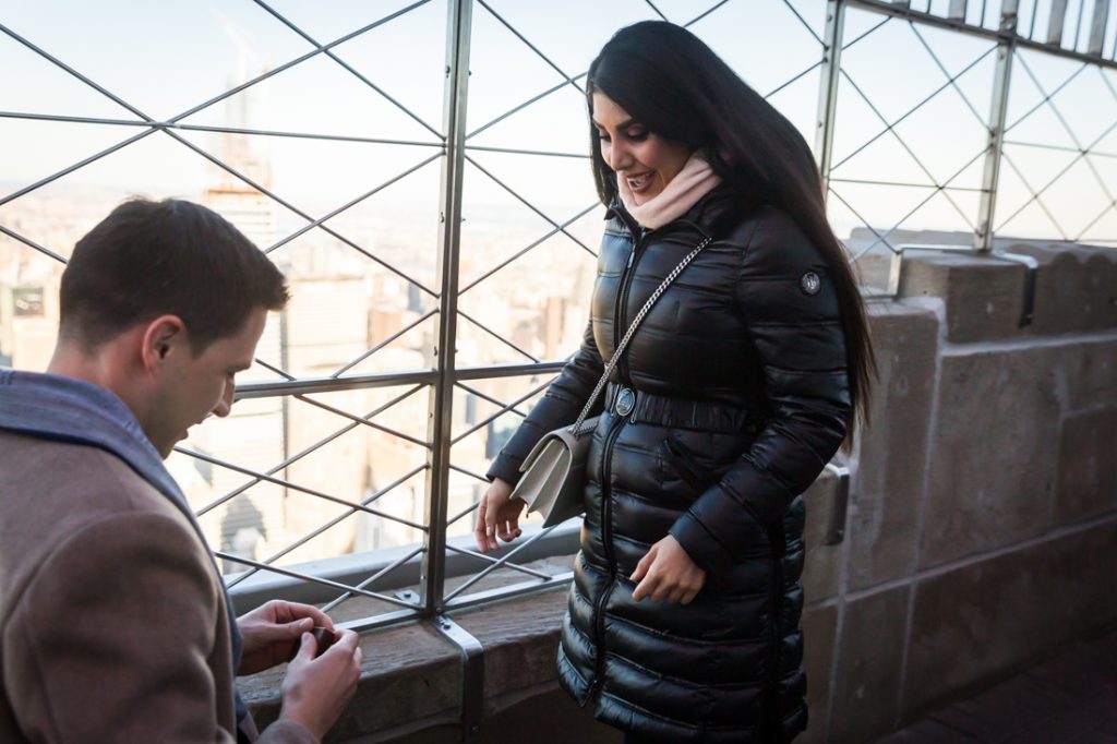 Woman looking surprised during proposal on top of the Empire State Building