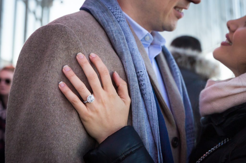 Close up of woman's hand with large engagement ring on man's jacket
