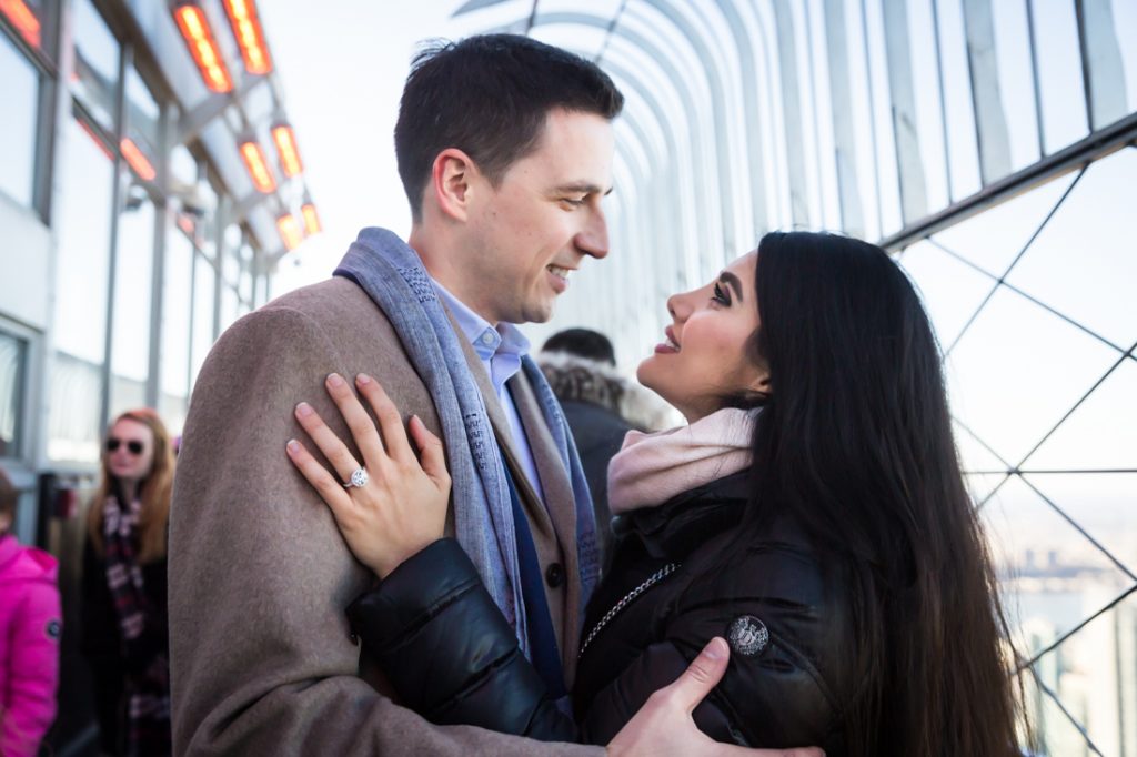 Couple together with woman's hand with large engagement ring on man's jacket