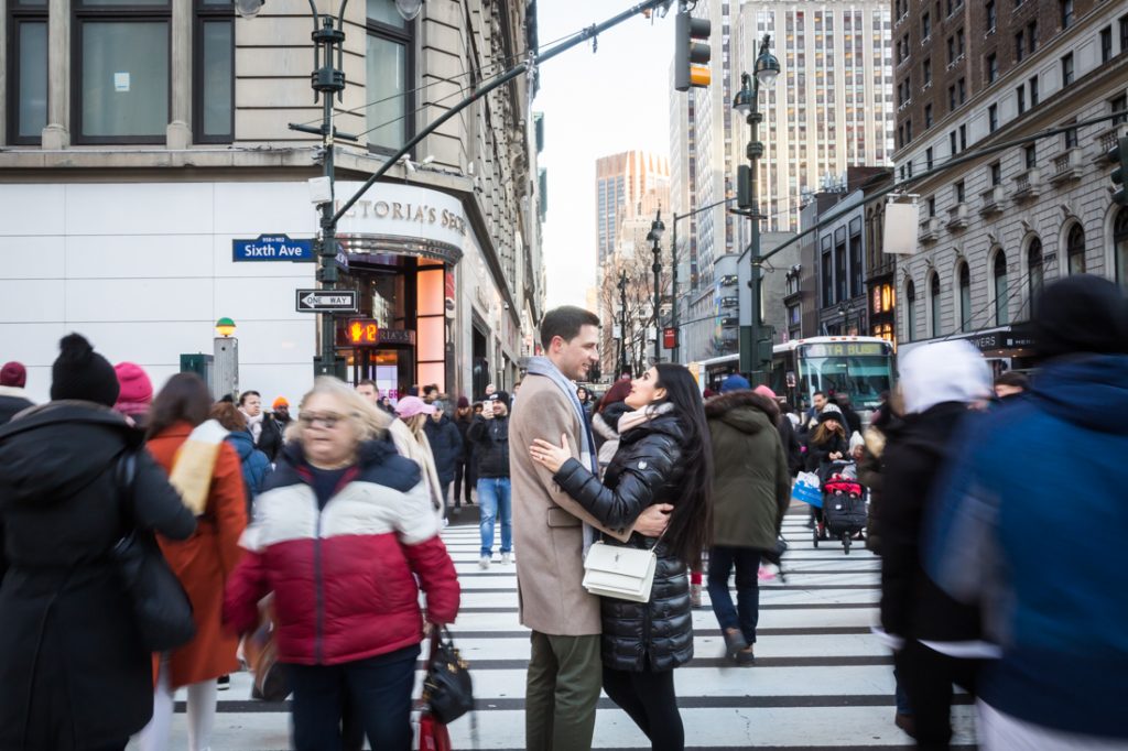 Couple hugging in the middle of crosswalk with blur of strangers