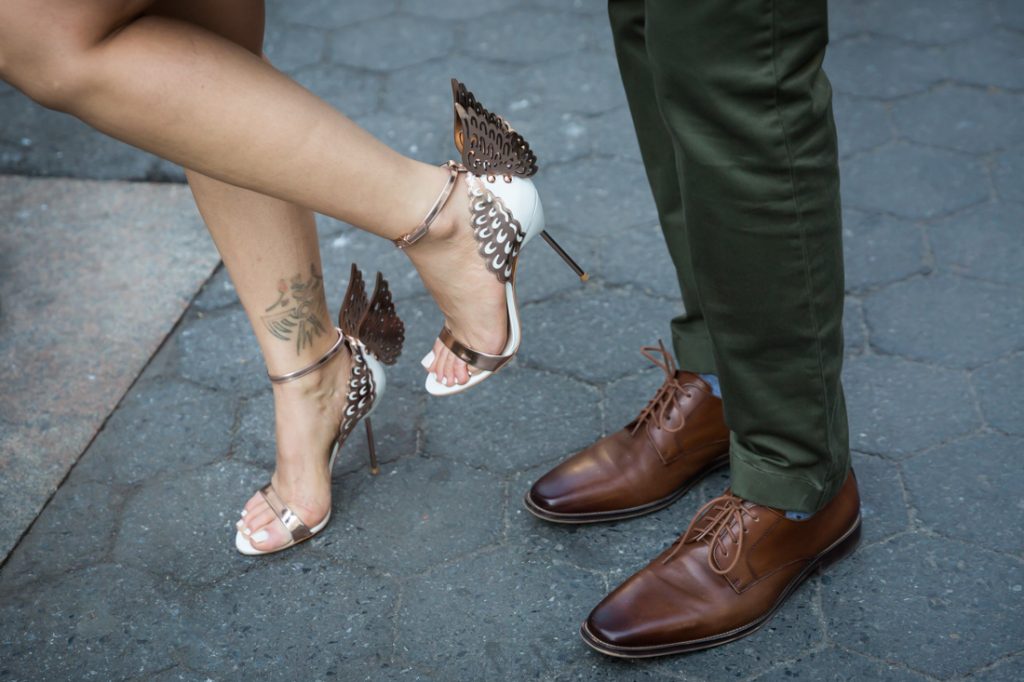 Close up on woman wearing winged sandals and man wearing brown shoes