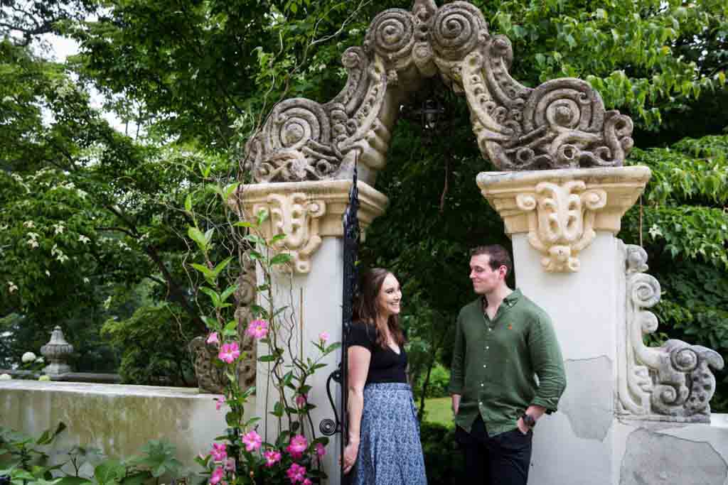 Couple standing in front of intricate gate at the Vanderbilt Museum