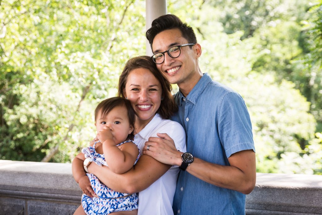 Mother, father, and baby sucking thumb during Belvedere Castle family portrait in Central Park
