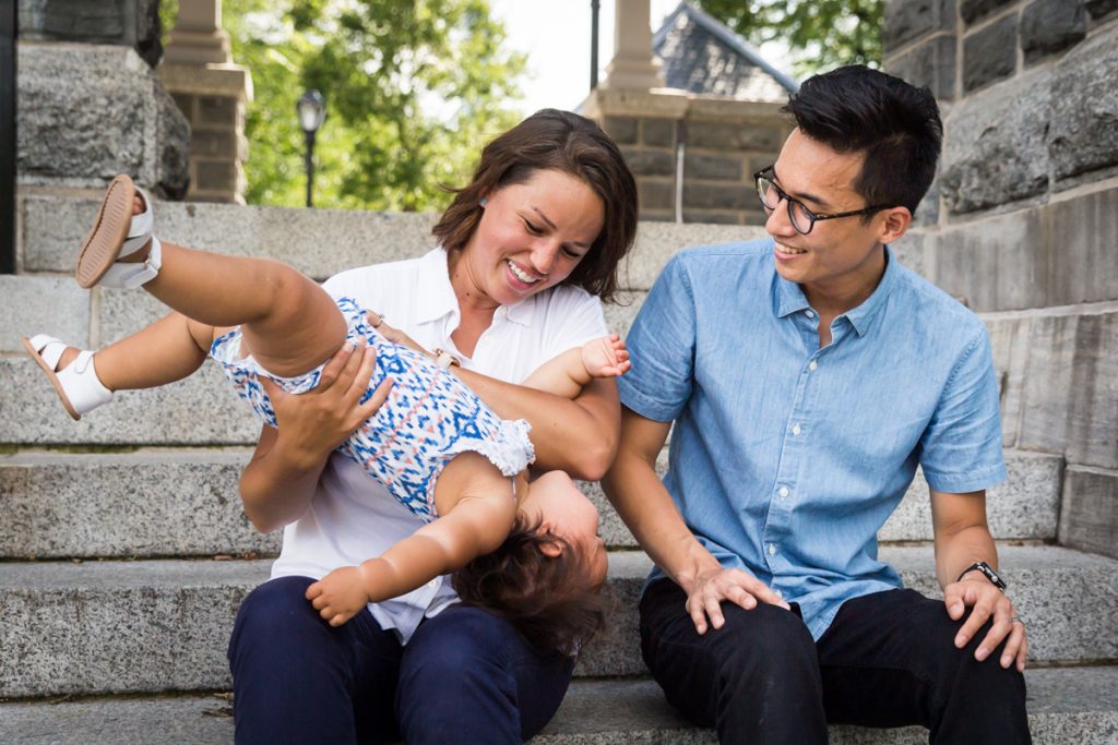 Parents holding squirmy toddler on steps of Belvedere Castle