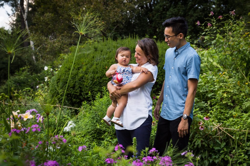 Parents holding baby in Shakespeare Garden in Central Park
