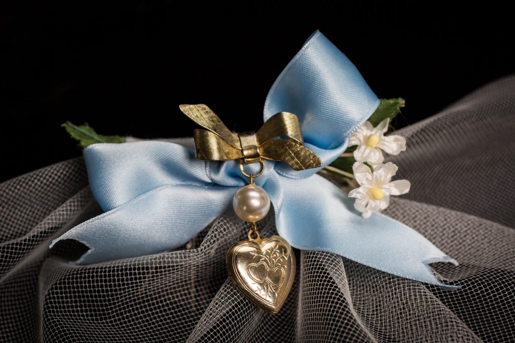 Close up on bridal veil with blue bow and heart locket