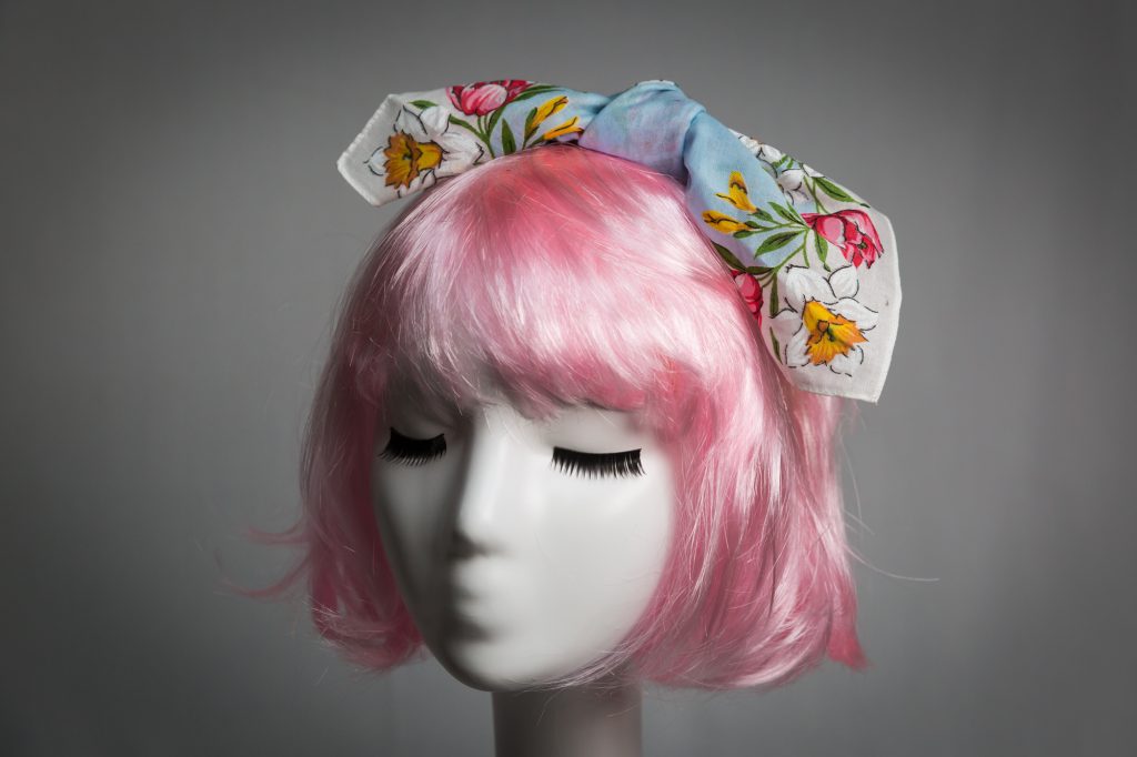 Pink haired mannequin wearing light blue and floral tied fabric headband