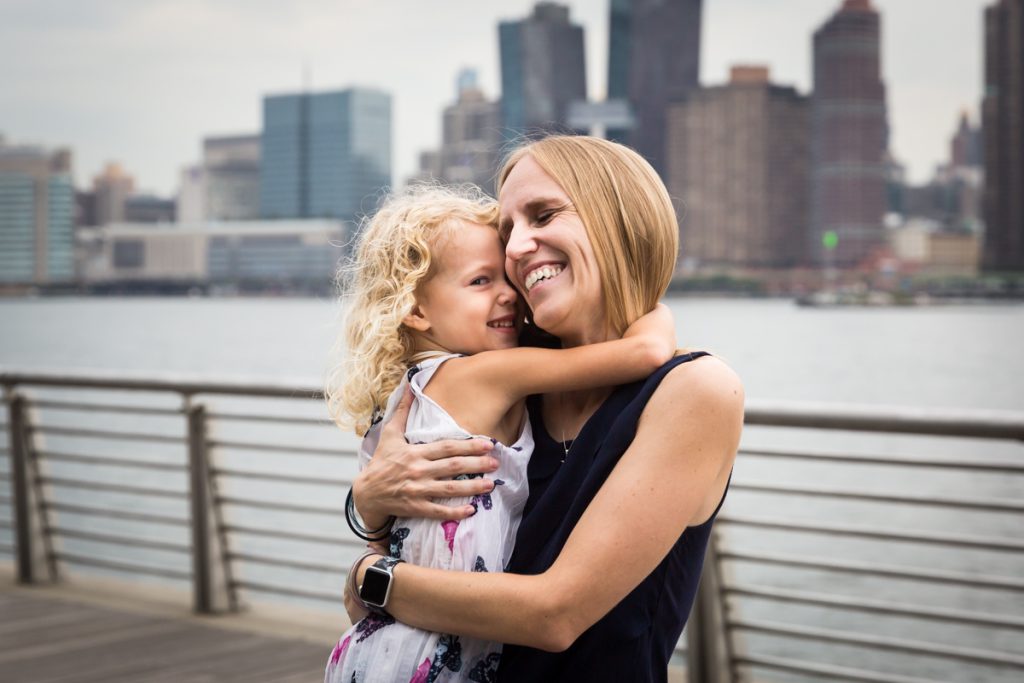 Mother hugging blond daughter during a Gantry Plaza family portrait session