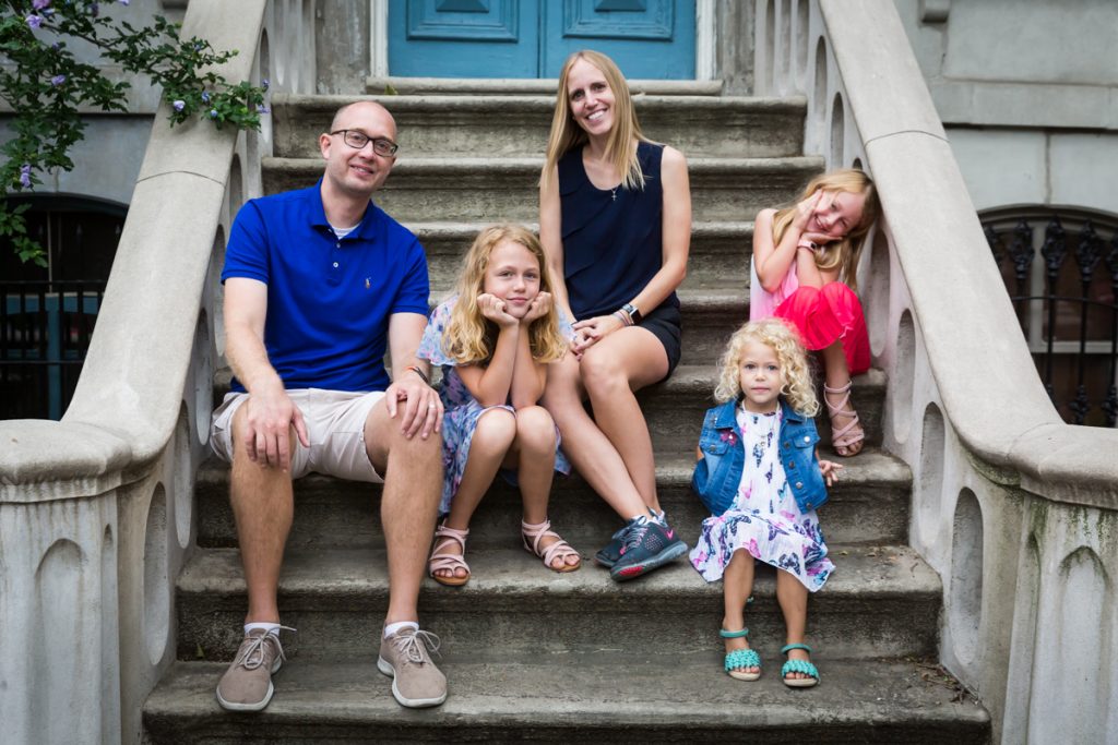 Family sitting on steps of brownstone in Hunters Point Historic District