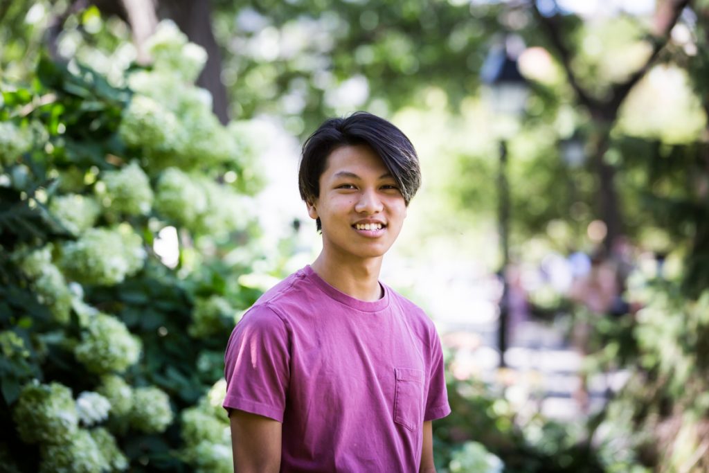 Young man wearing pink t-shirt during Washington Square Park family portrait