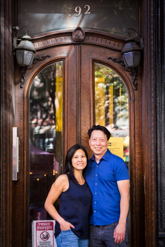 Couple standing in front of wood and glass door in West Village