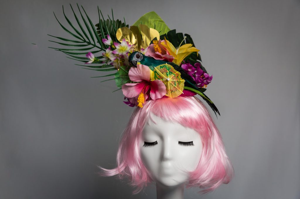 Pink haired mannequin wearing tiki parrot fascinator by Chapeau A Go Go