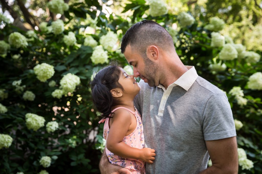 Father and daughter touching noses during a Washington Square Park family portrait