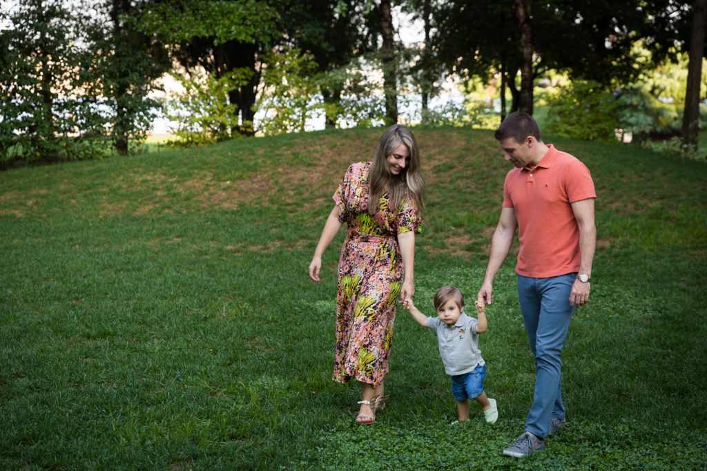 Parents leading little boy by the hand during a Chelsea Waterside Park family portrait session