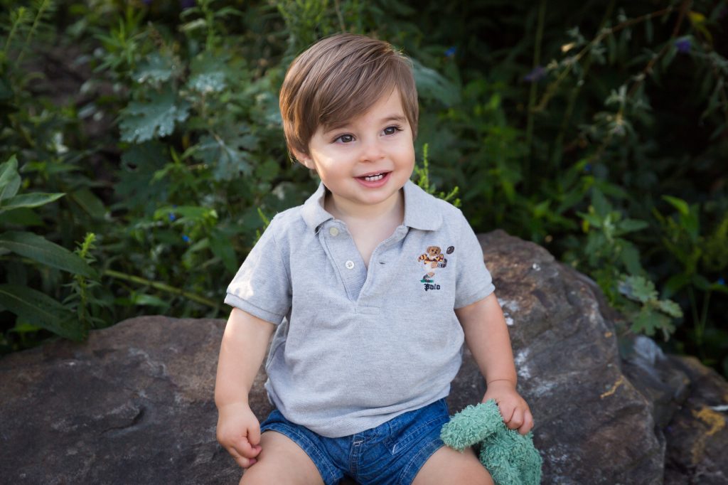 Little boy sitting on rock during a Chelsea Waterside Park family portrait session