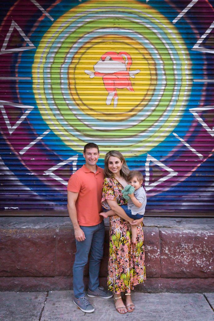 Parents and little son in front of colorful mural