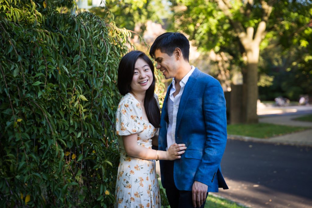 Couple in front of bush on Greenway Terrace during Forest Hills engagement shoot