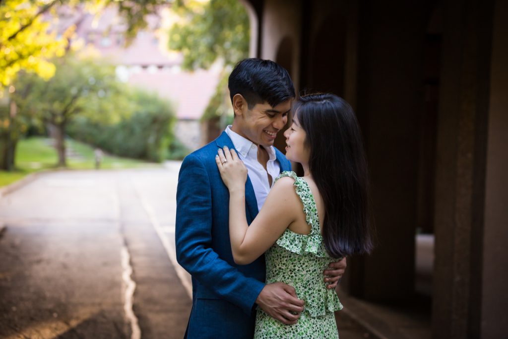 Couple hugging in archway during Queens engagement photo session
