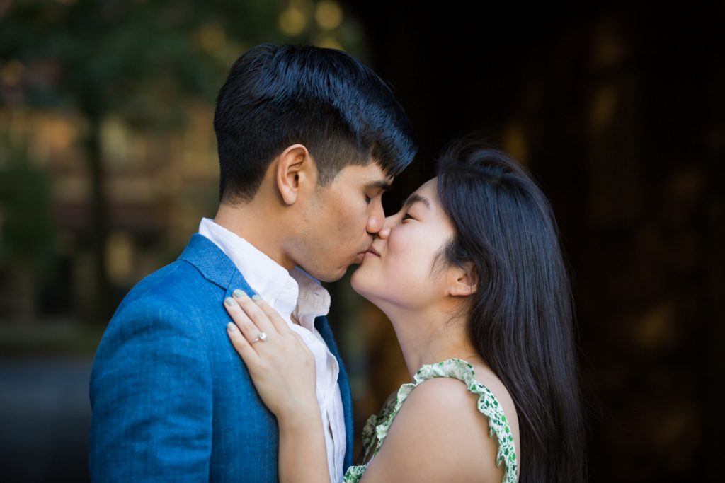 Couple kissing in dark archway during Forest Hills engagement session