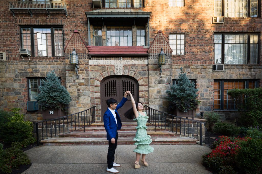 Couple dancing in front of Forest Hills Inn Apartments during Forest Hills engagement shoot 