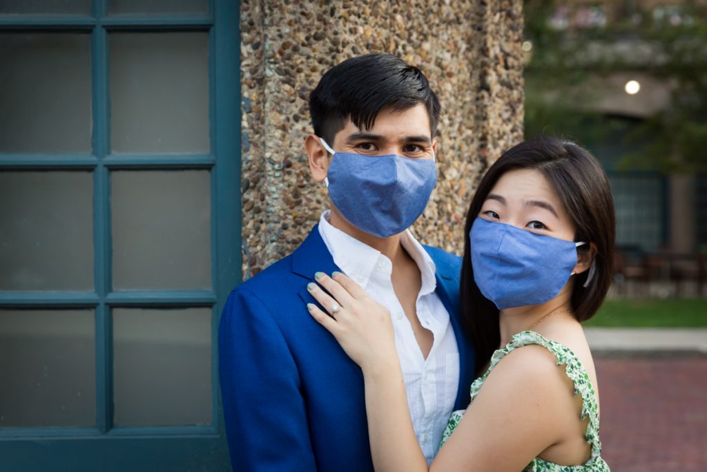 Couple wearing blue masks hugging during Forest Hills engagement shoot