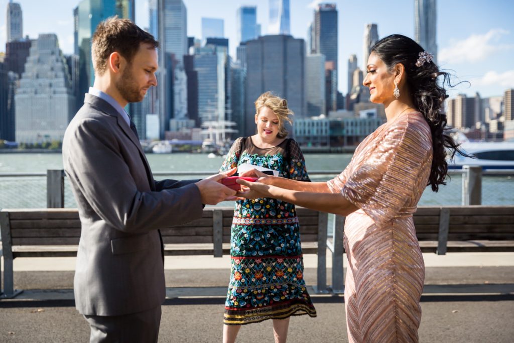 Bride and groom swapping ring boxes during Brooklyn Bridge Park wedding ceremony