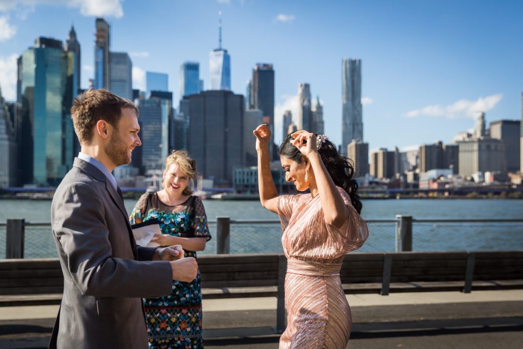 Groom watching bride dance for an article on how to get married in Brooklyn Bridge Park