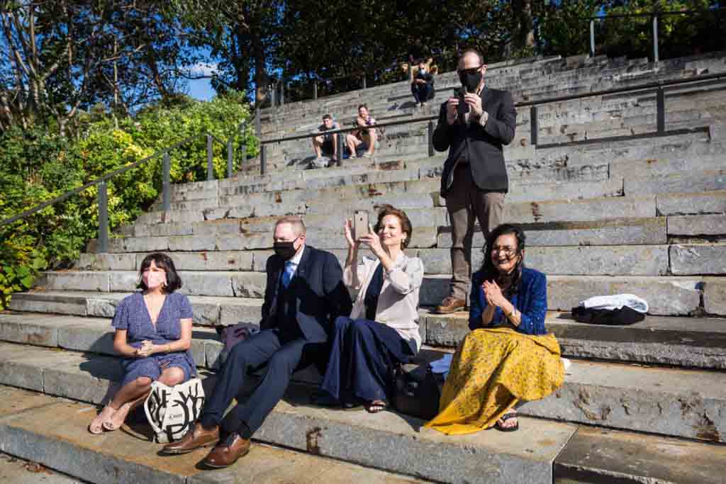 Guests sitting on Granite Prospect steps for an article on how to get married in Brooklyn Bridge Park