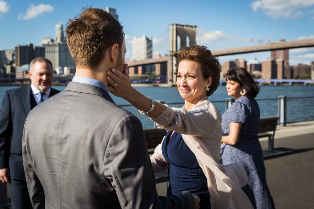 Mother touching son's cheek during Brooklyn Bridge Park wedding ceremony